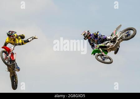 I piloti di MotoX stunt che volano in aria all'evento Goodwood Festival of Speed, Regno Unito. EVENTO GAS (Goodwood Action Sports). Coppia di acrobazie motociclistiche Foto Stock