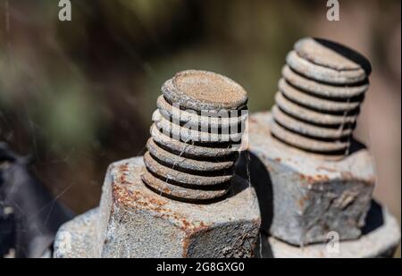 Fotografia della filettatura di un bullone e di un dado galvanizzati arrugginiti che fissano un cavo in acciaio in un nastro di spider Foto Stock