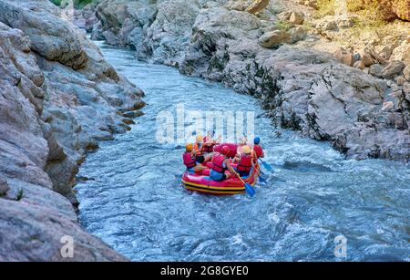 Gruppo di turisti che lottano con il forte torrente di montagna. Foto Stock