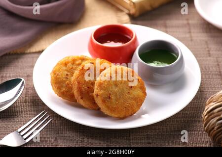 Indian Food - Alo ki Tikki (patatine di patate) servito con chutneys Foto Stock