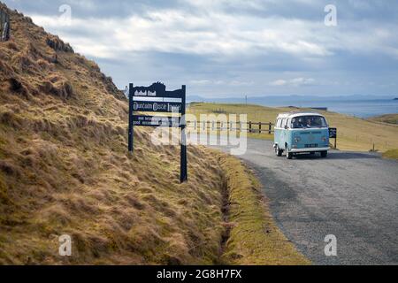 Beetles VW guidando dal segno del Duntulm Castle Hotel sulla strada stretta di campagna di Isle of Sky, Scozia - Regno Unito. Foto Stock