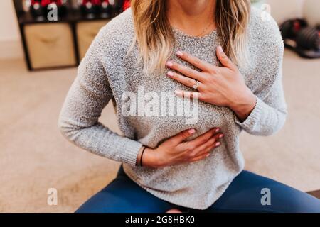 Primo piano di meditating donna nella sua palestra domestica Foto Stock