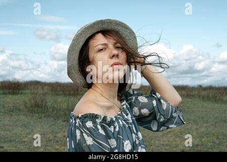 Ritratto di una ragazza in un cappello sul campo, guardando la macchina fotografica. Foto Stock