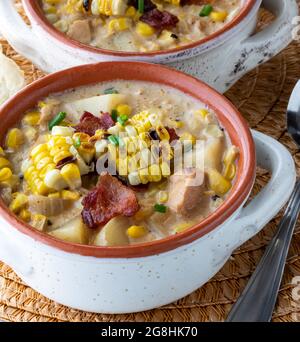 Dai un'occhiata da vicino a una zuppa di coccodrillo ripiena di pollo e zuppa di mais, ricoperta di mais alla griglia, pancetta e erba cipollina. Foto Stock