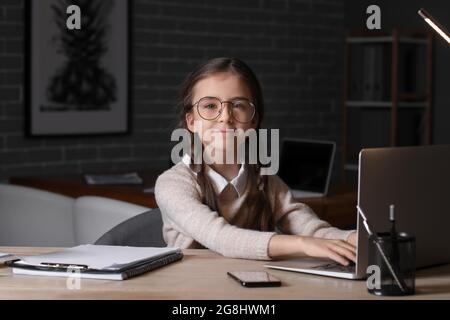 Carino piccola donna d'affari che usa il computer portatile in ufficio di notte Foto Stock