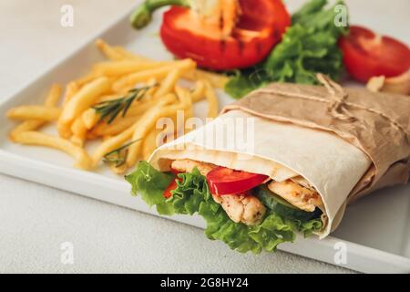 Gustoso doner kebab e patatine fritte su sfondo chiaro, primo piano Foto Stock