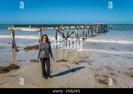 Una turista femminile si trova di fronte al molo abbandonato sulla vecchia stazione di telegrafia Eucla sulla costa di Nullarbor dell'Australia Occidentale. Foto Stock