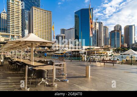 Tavoli vuoti nei ristoranti all'aperto di Circular Quay, Sydney, Australia durante il blocco. Cielo blu e skyline della città Foto Stock