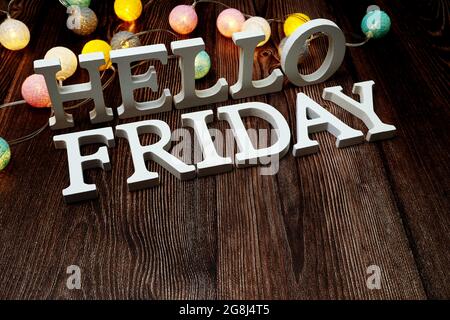 Lettere alfabetiche Hello Friday con decorazione a palline di cotone a LED su sfondo in legno Foto Stock