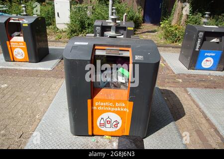 Separazione dei rifiuti con contenitori sotterranei separati per plastica e carta. Estate, villaggio olandese. Paesi Bassi, Foto Stock