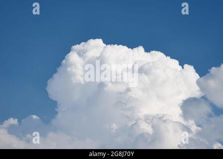 Grandi nuvole bianche soffici su cielo blu chiaro. Sfondo cielo nuvoloso con spazio di copia. Primo piano di Cumulus Cloud Foto Stock
