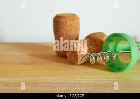 Due tappi di champagne e un cavatappi si trovano su un tavolo di legno. Primo piano. Foto Stock