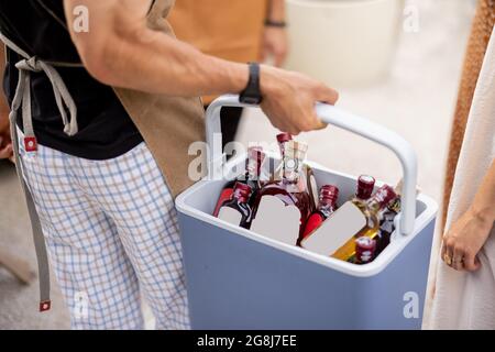 Amici con frigo pieno di alcol durante la festa all'aperto Foto Stock