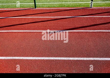 Tapis roulant rosso sul campo sportivo. Pista da corsa sullo stadio Foto Stock