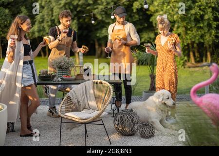 Giovani amici con bevande in cortile Foto Stock