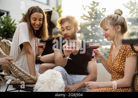 Amici con cane e bevande in cortile Foto Stock