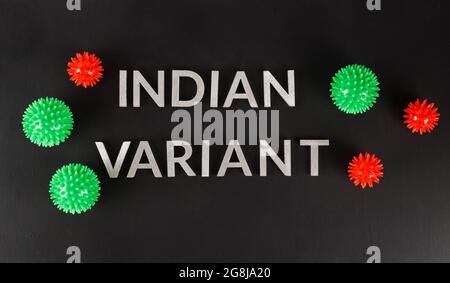 parole variante indiana posata con lettere in metallo d'argento superficie nera opaca con piccoli modelli di virus rosso e verde in prospettiva piana Foto Stock