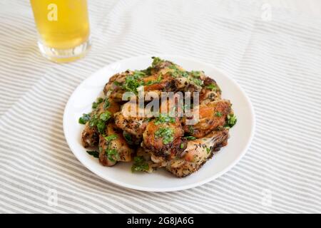 Ali di pollo al parmigiano di aglio fatte in casa con birra fredda, vista laterale. Foto Stock