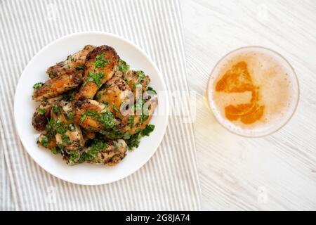 Ali di pollo al parmigiano di aglio fatte in casa con birra fredda, vista dall'alto. Posa piatta, sovratesta, dall'alto. Foto Stock