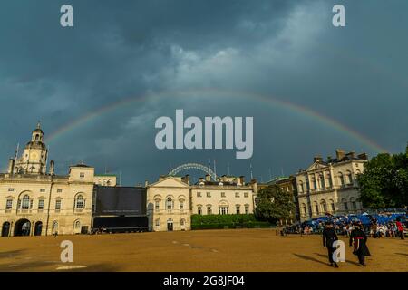 Londra, Regno Unito. 20 luglio 2021. La pioggia è caduta e brevemente ci è stato un arcobaleno sopra le guardie del cavallo - membri delle bande del Grenadier, Coldstream, Scots, Le guardie irlandesi e gallesi e i rappresentanti del 1° Battaglione Grenadier Corps of Drums eseguono la Sword & the Crown, che comprende arrangiamenti da parte dei membri della band e un'interpretazione della musica solitamente associata con l'agente segreto James Bond. La prima notte degli spettacoli che si svolgono il 20/21/22 luglio sulla Horse Guards Parade. Londra, Regno Unito. 20 Jul 2021. Credit: Guy Bell/Alamy Live News Foto Stock