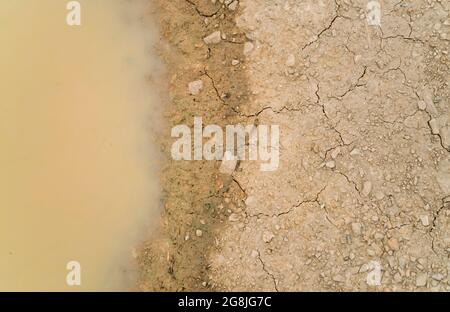 Acqua puddle su terreno sporco. Foto Stock