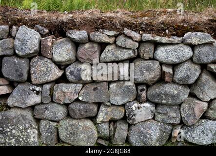 Muro fatto di massi e tappeto erboso in un paese Foto Stock