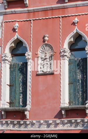 Dettaglio architettonico sulla facciata dell'edificio tra due finestre in stile gotico sul Canal Grande, Venezia, Italia Foto Stock