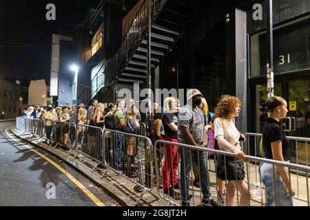 I Clubbers si dirigono al night club Oval Space nelle prime ore del 'Freedom Day', dove i locali di musica dal vivo sono stati autorizzati a riaprire alle 00.01 del 19 luglio. Foto Stock