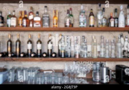 Liquore bar sfondo con bottiglie di bevande alcoliche sfocate. Ambiente luminoso. Foto Stock