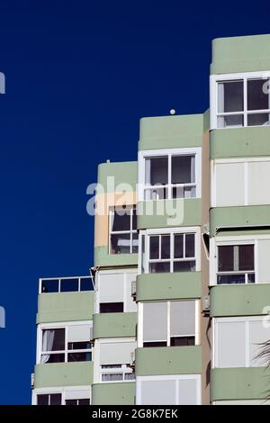 Torrox Costa, Spagna condominio sul mare spagnolo sulla Costa del Sol austere, colorata costruzione modernista, contro un cielo blu chiaro Foto Stock