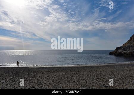 Spiaggia Cala del canuelo, Spagna appartata spiaggia sabbiosa in una suggestiva baia rocciosa tra Nerja e la Herradura sulla Costa del Sol nuvola luguente e blu s. Foto Stock