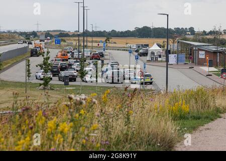 Heiligenhafen, Germania. 21 luglio 2021. Auto parcheggiate presso l'area di sosta Ostseeblick vicino a Heiligenhafen. Un impianto P-WC è stato aperto qui sulla A1 verso Fehmarn come progetto pilota. Oltre alle strutture sanitarie a energia solare, i viaggiatori troveranno anche aree per picnic, aree per esercizi per cani, attrezzature fitness, quattro stazioni di ricarica rapida per auto elettriche e Wi-Fi. La fermata di riposo era stata convertita per conto della filiale di Autobahn GmbH Northern. Credit: Frank Molter/dpa/Alamy Live News Foto Stock