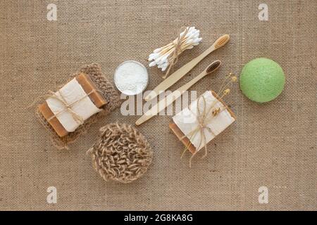 Set di diversi strumenti naturali per il bagno, stile di vita sostenibile e concetto zero rifiuti. Spazzolini da denti in legno, bastoncini di bambù, sapone, polvere da denti e spugna Foto Stock