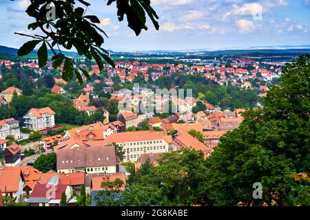 Vista su alberi e cespugli fino ai tetti della piccola città di Blankenburg in Sassonia-Anhalt, Germania, al margine settentrionale delle montagne Harz Foto Stock