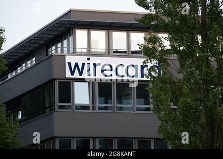 Ein gezoomtes Bild zeigt das Logo der Wirecard wie es leuchtet. Blick auf die Zentrale des insolventen Dax Unternehmens Wirecard. Nachdem die Wirtschaftsprüfer Ernst & Young ( EY ) das Testat verweigert hatten und 1, 9 Milliarden Euro fehlen, konnte Wirecard die Angestellten nicht mehr bezahlen. Der ehemalige CEO Markus Braun saß zwischenzeitlich in Untersuchungshaft und der ehemalige COO Jan Marsalek ist untergetaucht und wird mit Haftbefehl gesucht. – Vista generale sulla sede del fallimento del fornitore globale di servizi finanziari e di tecnologia Internet Wirecard ad Aschheim, nei pressi di Monaco di Baviera. Foto Stock