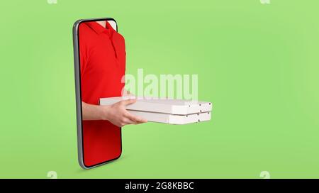 Un addetto alla consegna che tiene la pizza, in piedi su uno smartphone Foto Stock