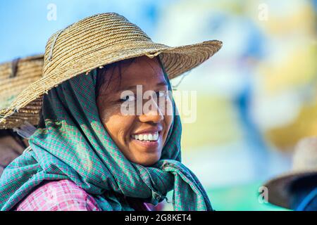 Giovane abbastanza birmano lavoratore di strada operaio con denti bianchi brillanti posa in strada, Monywa, Myanmar Foto Stock