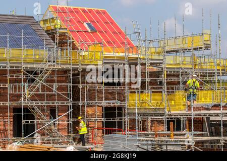 Keepmoat case sviluppatori di proprietà; fasi di costruzione nel sito di sviluppo a Chorley. Costruttori iniziare la costruzione su questo grande nuovo alloggiamento, tetti doghe di legno dormitore, bordo di cresta, travi e costruzione dormitori, membri del tetto, guancia bordo di legno soffit telaio e rivestimenti apex tetto in legno. Tetto spiovente dormitorio costruire su campo verde estate. Foto Stock