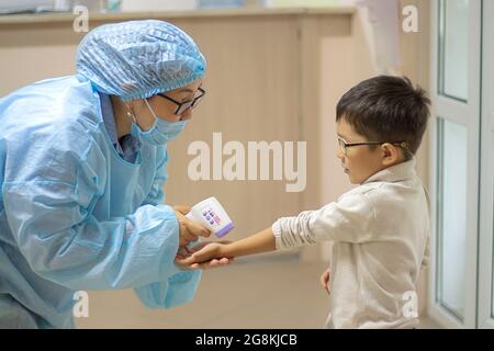 L'infermiere misura la temperatura corporea con un termometro a infrarossi  in africa di mezza età uomo americano Foto stock - Alamy