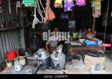 Dhaka, Bangladesh. 21 luglio 2021. Samir (8), seduto sul negozio di suo padre, mentre suo padre non è disponibile per il lavoro. Aiuta suo padre con il commercio. A causa di COVID-19 un sacco di bambini ha dovuto lasciare lo studio e ha iniziato ad aiutare la loro famiglia. (Credit Image: © Md. Rakibul Hasan/ZUMA Press Wire) Foto Stock