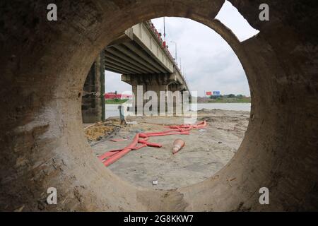 Narayanganj, Bangladesh. 21 luglio 2021. Il ponte Kanchan sul fiume Shitalaksha a Ruppanj a Narayanganj, un quartiere adiacente a Dhaka, sarà ampliato a causa del traffico extra sulla strada. I lavori sono già iniziati su un altro ponte accanto al vecchio. Attraverso la guardia notturna Thama mia si apprende che un altro ponte per il treno si dice sia costruito più tardi. Lo sviluppo è in corso, ma la dimensione del fiume è in declino e la navigabilità è in pericolo giorno per giorno. (Credit Image: © Md. Rakibul Hasan/ZUMA Press Wire) Foto Stock