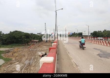 Narayanganj, Bangladesh. 21 luglio 2021. Il ponte Kanchan sul fiume Shitalaksha a Ruppanj a Narayanganj, un quartiere adiacente a Dhaka, sarà ampliato a causa del traffico extra sulla strada. I lavori sono già iniziati su un altro ponte accanto al vecchio. Attraverso la guardia notturna Thama mia si apprende che un altro ponte per il treno si dice sia costruito più tardi. Lo sviluppo è in corso, ma la dimensione del fiume è in declino e la navigabilità è in pericolo giorno per giorno. (Credit Image: © Md. Rakibul Hasan/ZUMA Press Wire) Foto Stock