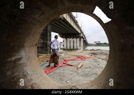 Narayanganj, Bangladesh. 21 luglio 2021. Il ponte Kanchan sul fiume Shitalaksha a Ruppanj a Narayanganj, un quartiere adiacente a Dhaka, sarà ampliato a causa del traffico extra sulla strada. I lavori sono già iniziati su un altro ponte accanto al vecchio. Attraverso la guardia notturna Thama mia si apprende che un altro ponte per il treno si dice sia costruito più tardi. Lo sviluppo è in corso, ma la dimensione del fiume è in declino e la navigabilità è in pericolo giorno per giorno. (Credit Image: © Md. Rakibul Hasan/ZUMA Press Wire) Foto Stock