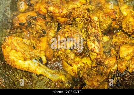 Preparazione di affumicando il curry caldo indiano del pollo, una delle delicatezze speziate dei cibi indiani. L'India è famosa per i suoi piatti gustosi e colorati in Asia. Foto Stock