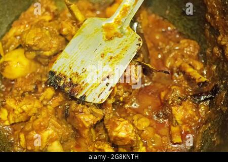 Preparazione di affumicando il curry caldo indiano del pollo, una delle delicatezze speziate dei cibi indiani. L'India è famosa per i suoi piatti gustosi e colorati in Asia. Foto Stock