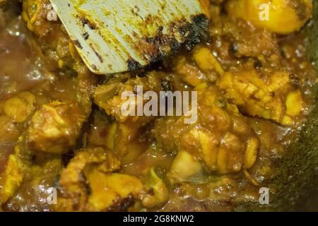 Preparazione di affumicando il curry caldo indiano del pollo, una delle delicatezze speziate dei cibi indiani. L'India è famosa per i suoi piatti gustosi e colorati in Asia. Foto Stock