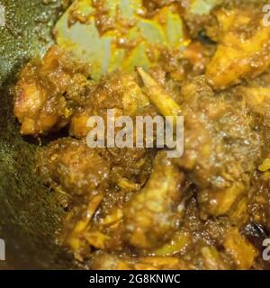 Preparazione di affumicando il curry caldo indiano del pollo, una delle delicatezze speziate dei cibi indiani. L'India è famosa per i suoi piatti gustosi e colorati in Asia. Foto Stock