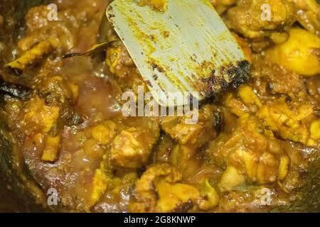 Preparazione di affumicando il curry caldo indiano del pollo, una delle delicatezze speziate dei cibi indiani. L'India è famosa per i suoi piatti gustosi e colorati in Asia. Foto Stock