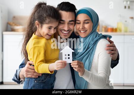 Felice Famiglia Islamica con la figlia piccola che tiene Cutout carta Casa Figura Foto Stock
