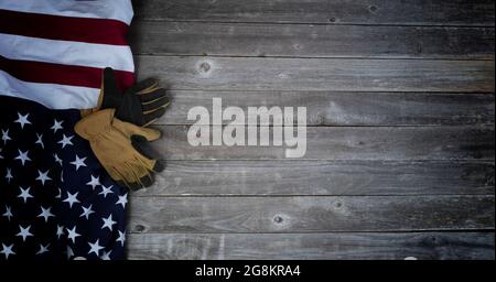 Grande bandiera americana e guanti da lavoro sul tempo vecchio legno per gli Stati Uniti di concetto di vacanza sfondo come lavoro, veterano, memoriale e Independence Day Foto Stock